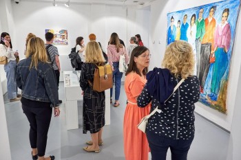 Umjetnici razgovaraju i stvaraju profesionalne kontakte na otvorenju izložbe